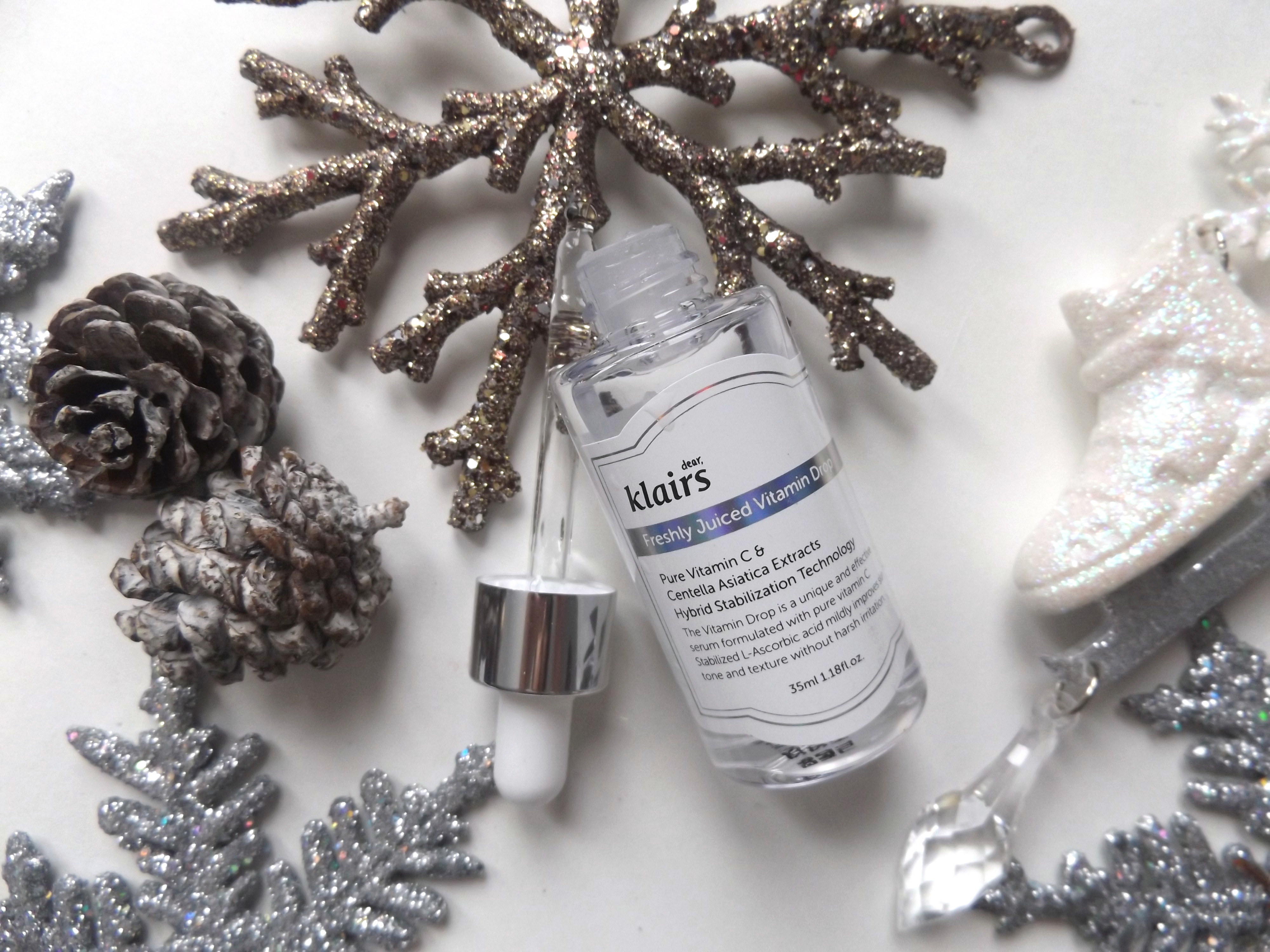 Klair's serum on top of snowflake, the pippet is laying beside the bottle. 