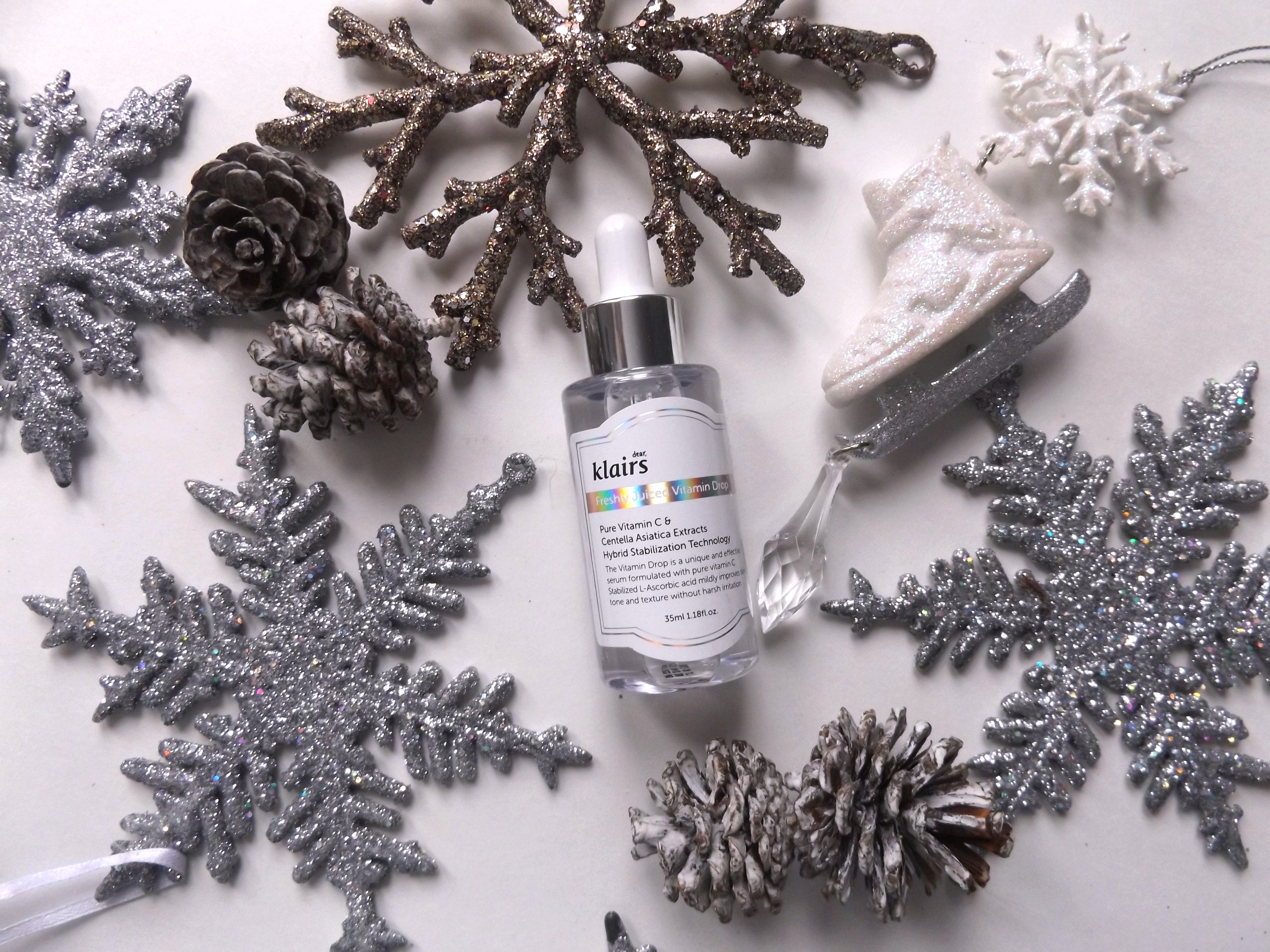 Klairs freshly juiced vitamin shot laying down, surrounded by snowflakes